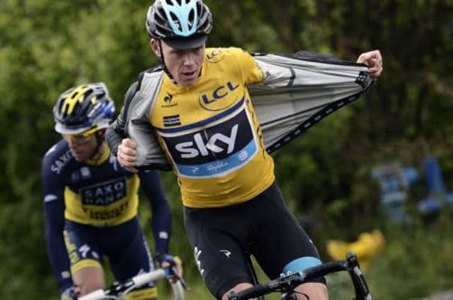 Team Sky rider Chris Froome removes his raincoat as he tackles the last stage of the Criterium du Dauphine. Picture: Getty