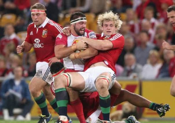James Hanson of Queensland Reds is tackled by Richie Gray and Mako Vunipola. Picture: Getty