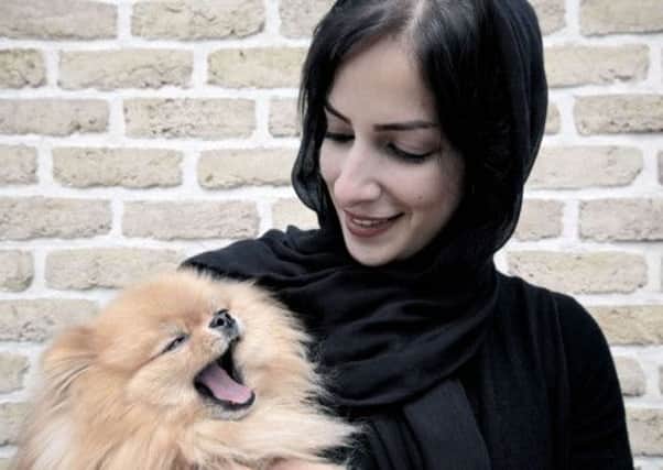 Iranian businesswoman Nahal poses for a picture with her pomeranian dog Toranj in her office in Tehran. Picture: Getty