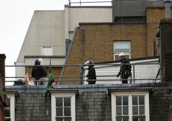 Riot police detain a man on a central London rooftop. Picture: Getty