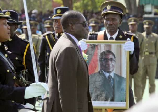 Robert Mugabe inspects the guard of honour during a police pass-out  parade in Harare yesterday. Picture: AP