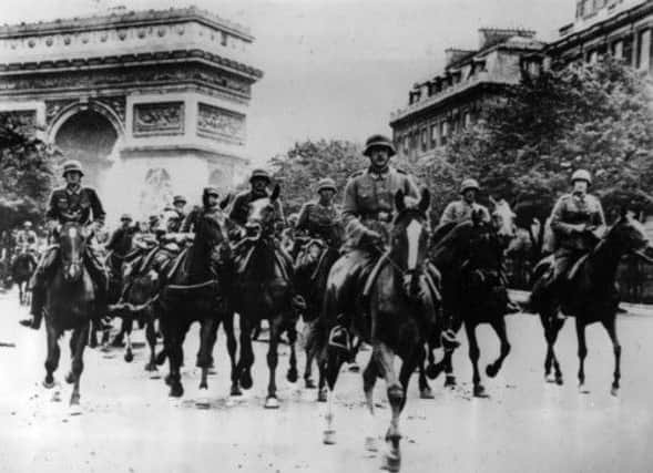 A column of German troops rides past the Arc de Triomphe as on this day in 1940 Hitlers army occupied Paris. Picture: Getty