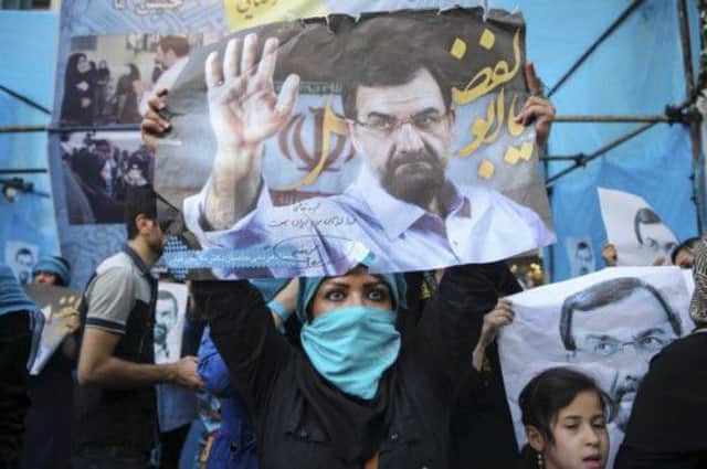 A supporter carries a campaign poster for Iranian presidential candidate Mohsen Rezaie. Picture: Reuters