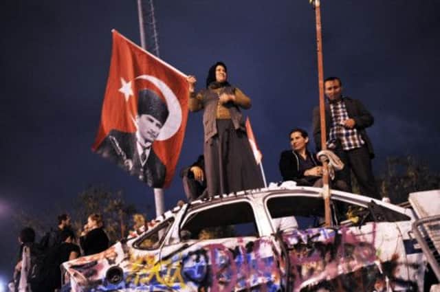A woman waves a flag bearing the image of of Mustafa Kemal Ataturk, founder of modern Turkey. Picture: Getty