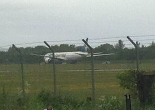 Police vehicles surround the grounded plane at Prestwick Airport. Picture: Hayley O'Rourke