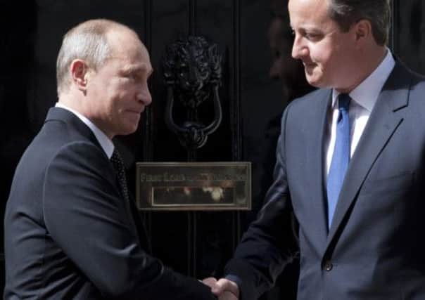 Vladimir Putin and PM David Cameron shake hands yesterday. Picture: Getty