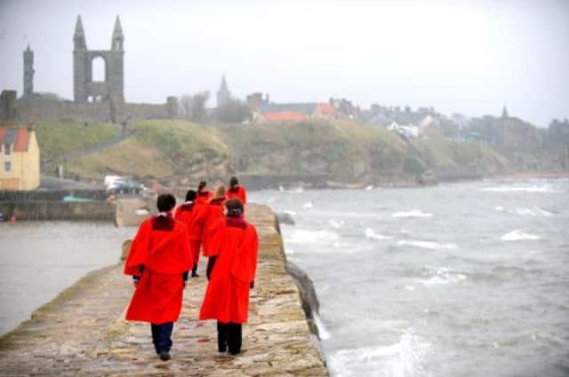 Students from the University of St Andrews walk along the harbour wall. Picture: Jane Barlow