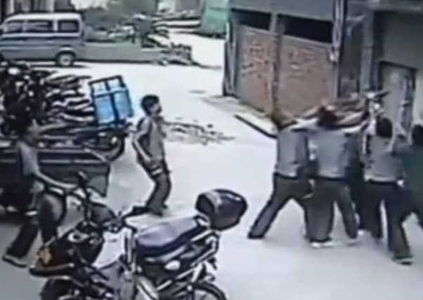 A toddler was caught by five workmen after dangling from a fourth floor window. Picture: Youtube