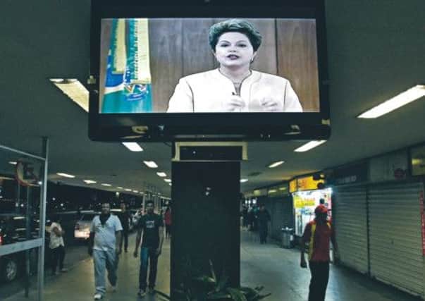 A message by Brazil's President Dilma Rousseff is broadcast live at the bus station in Brasilia, Brazil. Picture: AP