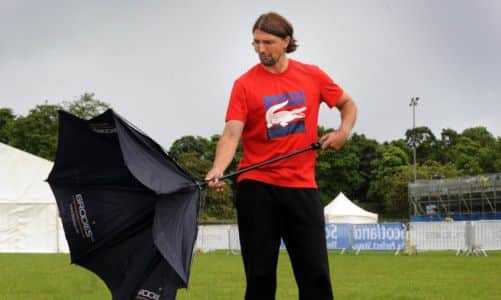 Goran Ivanisevic struggles with his umbrella in Edinburgh yesterday. Horizontal rain meant John McEnroe could play for just three minutes. Picture: Jane Barlow