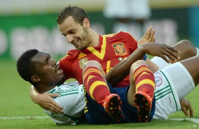 Spain forward Robert Soldado sees the funny side after getting tangled up with Nigerias Azubuike Egwuekwe. Picture: Getty