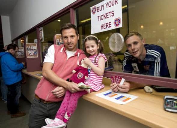Hearts player Kevin McHattie serves supporter Michael Turner his parent and child season ticket yesterday. Picture: SNS