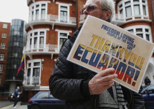 A man holds up a sign at the Ecuadorian embassy in London as a show of support to Edward Snowdon. Picture: Reuters