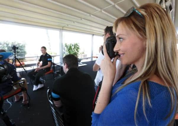 Michelle Cound, girlfriend of British cyclist Chris Froome, takes a photo during his interview with the media. Picture: Reuters