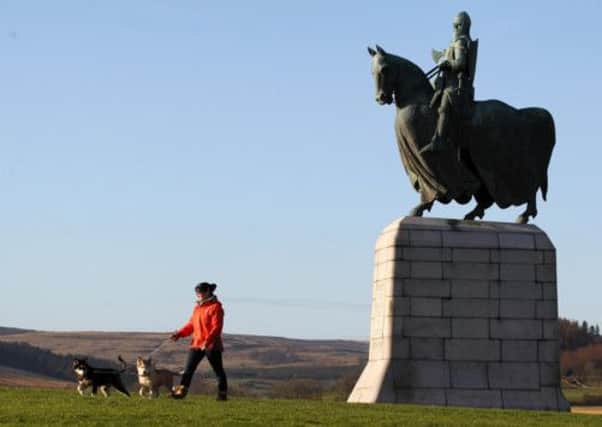 A woman walks her dog past a statue of Robert the Bruce at the site of the Battle of Bannockburn. Picture: PA