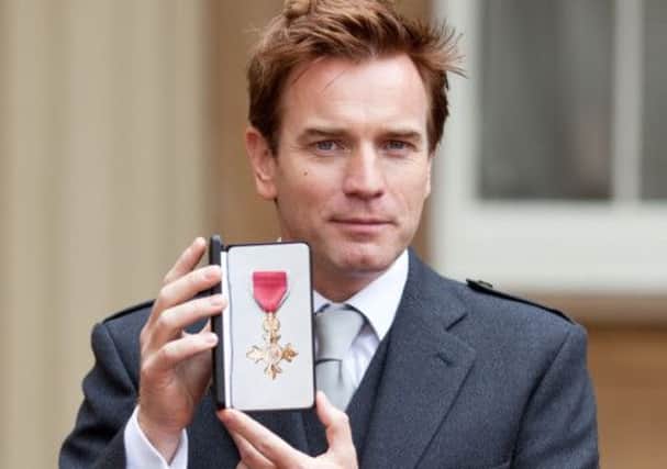 Ewan McGregor holds his OBE for services to drama and charity. Picture: Getty