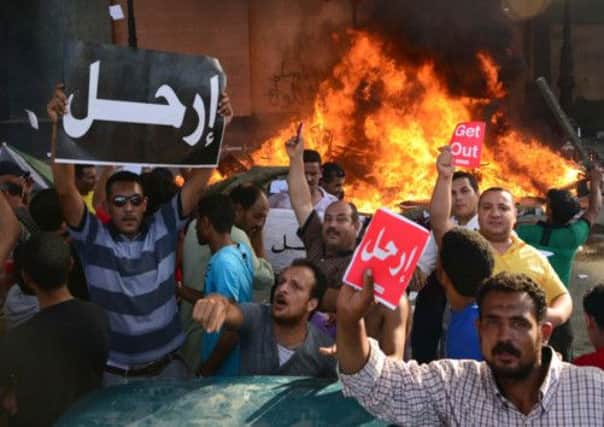 Opponents of Egypt's Islamist President Mohammed Morsi hold Arabic signs reading 'leave' in Alexandria. Picture: AP