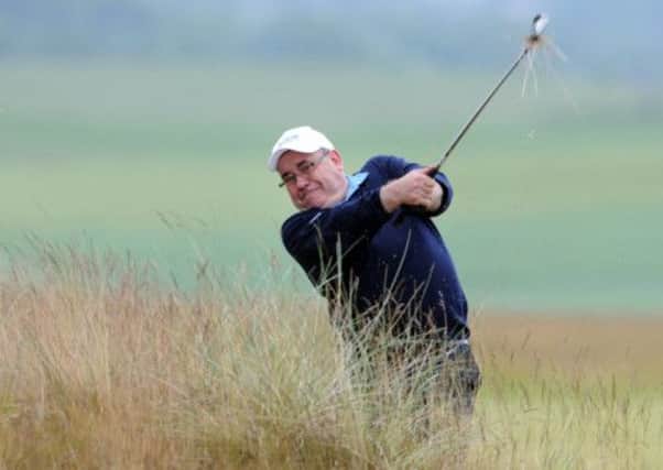 First Minister Alex Salmond hacks from the rough. Picture: Jane Barlow