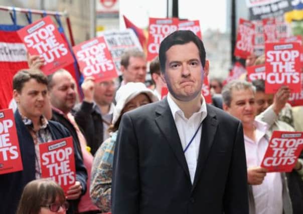 An anti-austerity campaigner wears a George Osborne mask. Picture: Getty