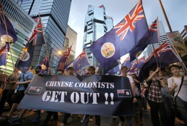 Colonial flags are waved at the annual prodemocracy march in Hong Kong. Picture: Vincent Yu/AP