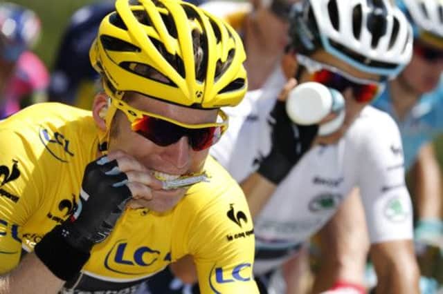 Overall race leader Jan Bakelants grabs a snack during a sweltering third stage yesterday. Picture: Getty