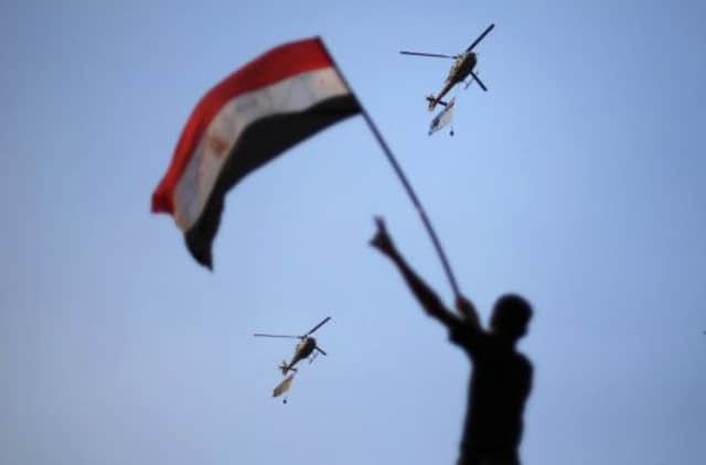 Egyptian military helicopters trailing national flags circled over Tahrir Square yesterday evening. Picture: Suhaib Salem/Reuters