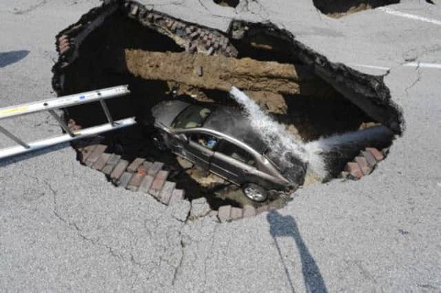 An Ohio sinkhole swallowed a car, with its driver briefly trapped inside. Picture: Reuters