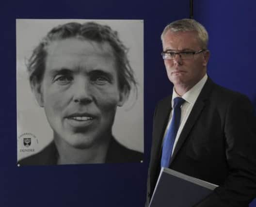DCI Keith Hardie with the facial reconstruction image of the victim. Picture: Julie Bull