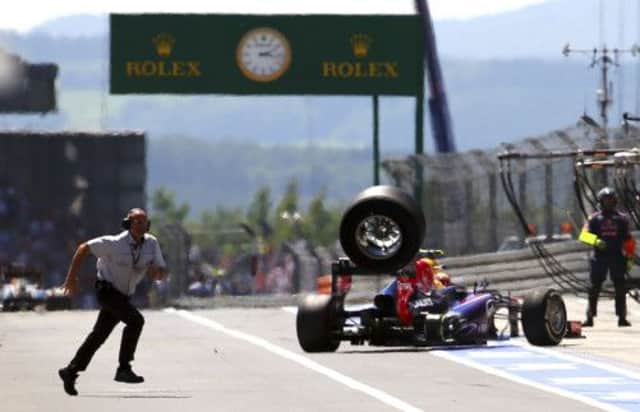 A wheel flies off the car of Mark Webber as he leaves the pit lane during the German Grand Prix yesterday. Picture: AP
