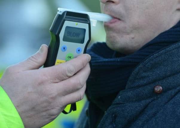 A motorist takes a breathaliser test administered by a police officer. Picture: Neil Hanna