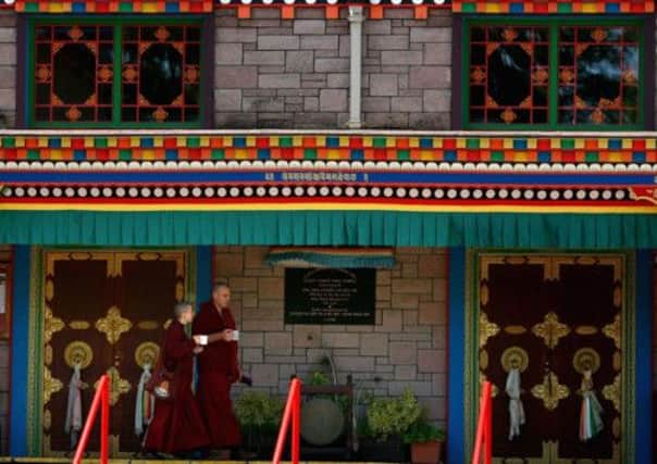 Monks at the Samye Ling Monastery and Tibetan Centre walk past the temple. Picture: Getty