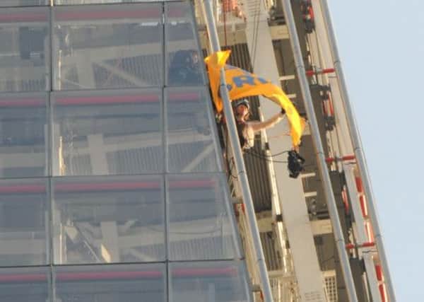 A Greenpeace activist unveils a Save The Arctic flag on top of the Shard in London. Picture: PA