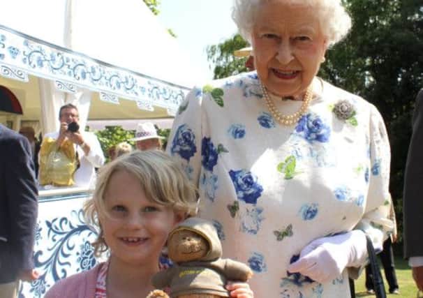 Jessica Fitch, Bertie the bear and the Queen at Buckingham Palace. Picture: PA