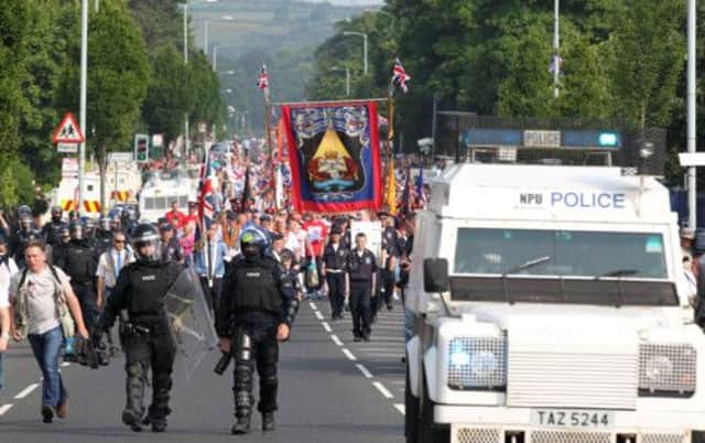 Police in riot gear escort protestant Orangemen through the Catholic Ardoyne district of Belfast. Picture: Getty