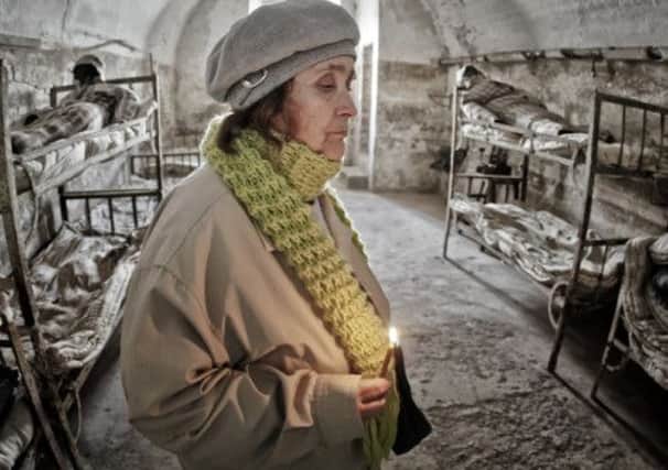 A woman holds a candle at the former prison at Jilava, Romania. Picture: AP