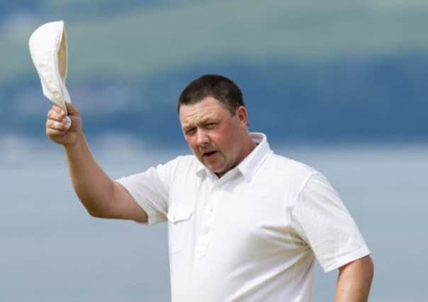 A delighted Chris Doak raises his cap in celebration of another fine round. Picture: SNS