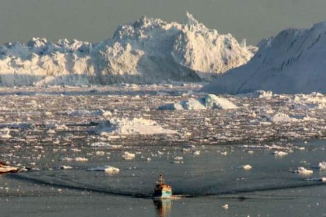 A boat skims through melting ice off Greenland. Picture: AFP
