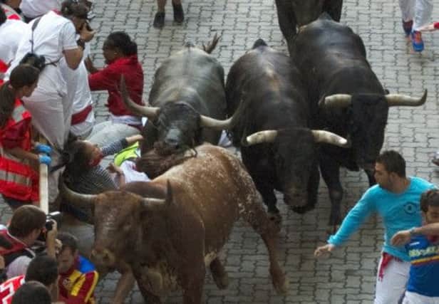 The Australian woman is caught by the bulls on the last of the Pamplona street runs. Picture: Reuters