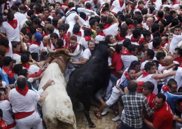 Runners attempt to evade onrushing bulls near the entrance to the bullring at the San Fermin festival in Pamplona, Spain. Picture: AP