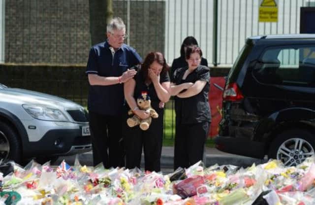 Lee Rigbys family look at floral tributes left by well-wishers outside Woolwich Barracks. Picture: AP Photo