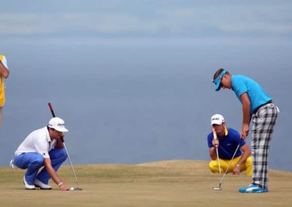 Ian Poulter, right, putts on the 11th green during the first round at The Open. Picture: Getty