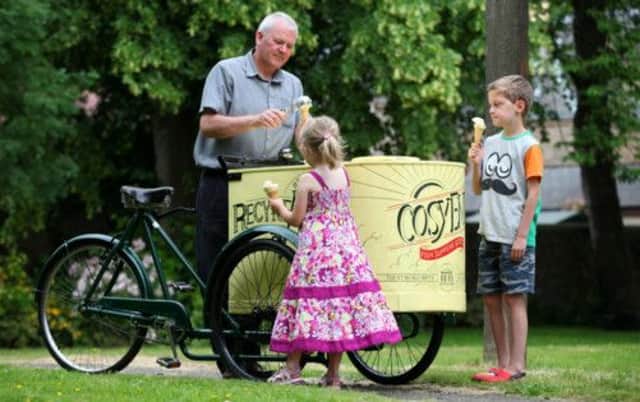 Vincent Connell serves out ice creams to Niamh Reid, 5 and Lewis Timpson, 9, from a rare ice cream vendors tricycle from the 1930s