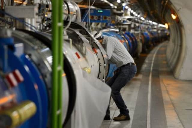 A scientist looks at a section of the CERN's Large Hadron Collider. Picture: Getty