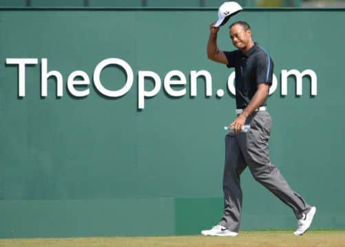 Tiger Woods doffs his cap to the large crowd as the world No.1 walks onto the first tee for this engrossing third round with Lee Westwood at Muirfield yesterday. Picture: Ian Rutherford