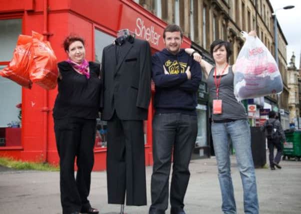 Kevin Bridges with shop manager Lynne Bracken, left, and volunteer Clara McAvoy at the Shelter Scotland shop on Great Western Road, Glasgow. Picture: PA