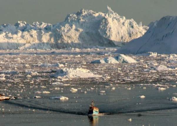 A boat skims through melting ice off Greenland. Picture: AFP/ Getty
