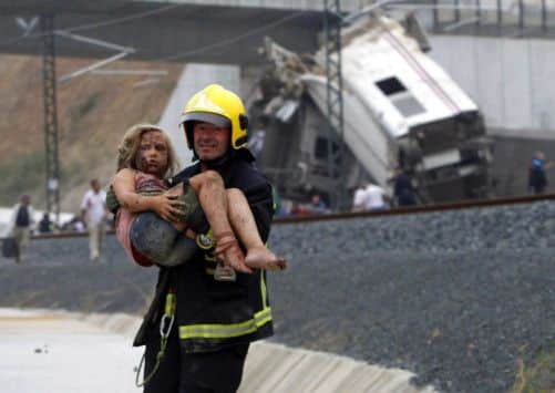 A fireman carries an injured young girl from the scene following the train crash. Picture: Getty