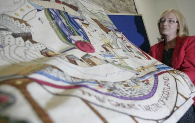Holyrood's Presiding Officer Tricia Marwick sews the final stitch on the world's longest tapestry