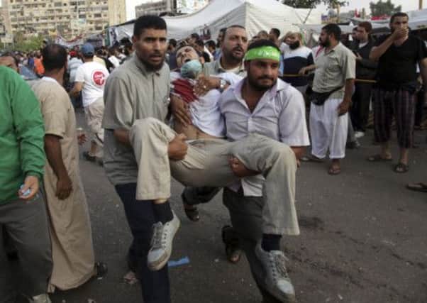 Supporters of Egypt's ousted President Mohammed Morsi carry an injured man to a field hospital. Picture: AP