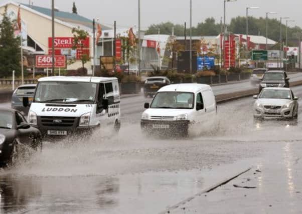 Vehicles make their way through partially flooded roads during heavy rain in Glasgow on Tuesday. Picture: PA